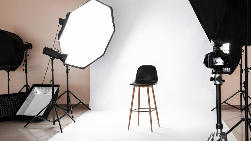 Helles Fotostudio mit Stuhl und Beleuchtung für Portraitaufnahmen.